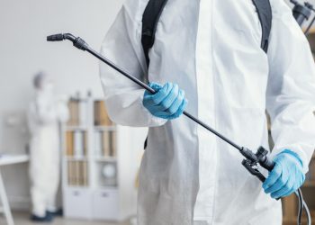 person-disinfecting-dangerous-area-while-wearing-protective-suit
